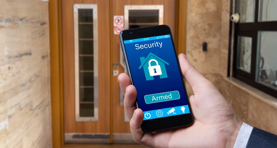 Individual using mobile device to arm a home security system